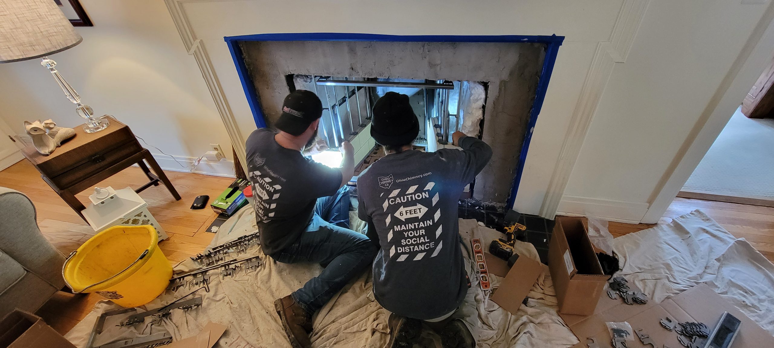 two workers installing a fireplace